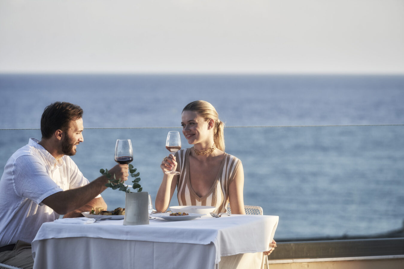Couple enjoying exquisite flavours at one of the best restaurants in Rhodes coupled with seaside views, at H Hotels Collection.