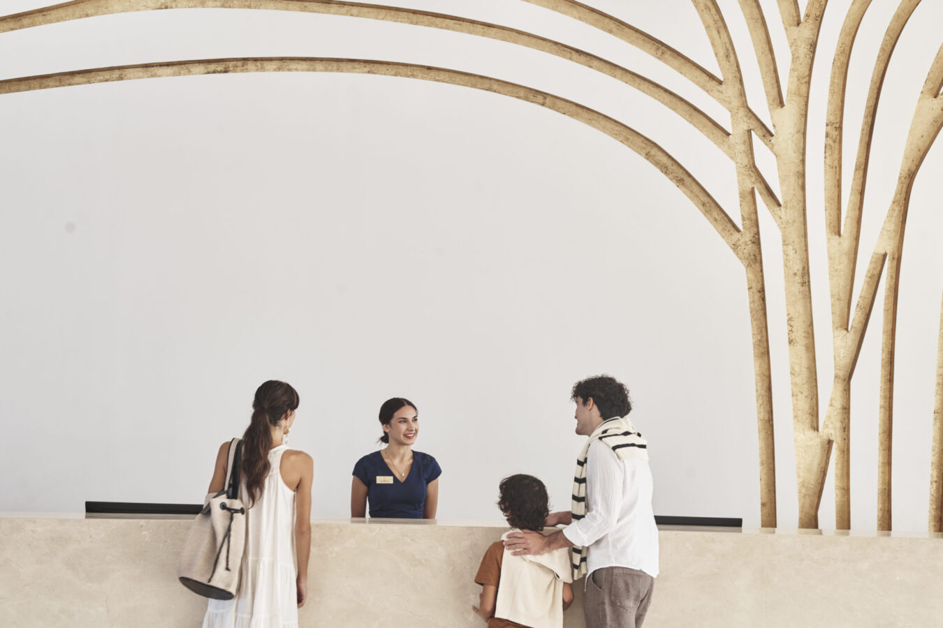 Family of three checking into the family-oriented Princess Andriana Resort & Spa in Rhodes island, one of the best places to visit in October with family.