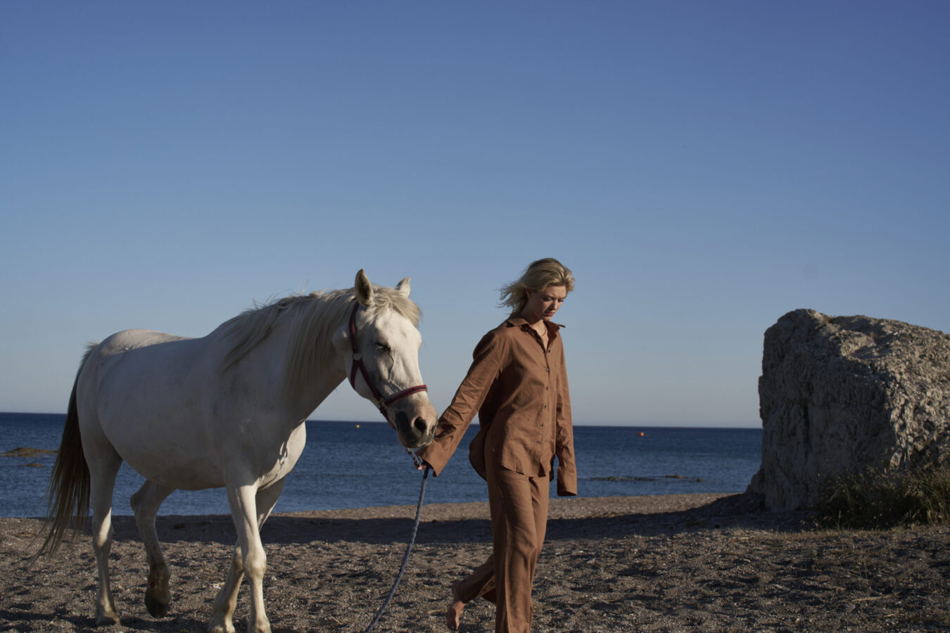Guest and horse walking on the beach, captured during their Autumn excursions in Rhodes.