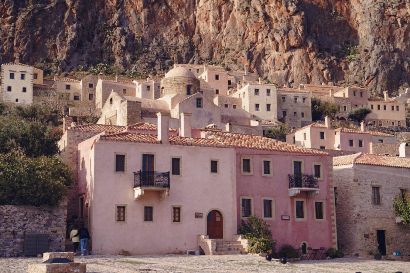 View of the colourful houses that sit on Monemvasia rock, one of the most picturesque destinations for travellers considering where to go in Greece in winter.