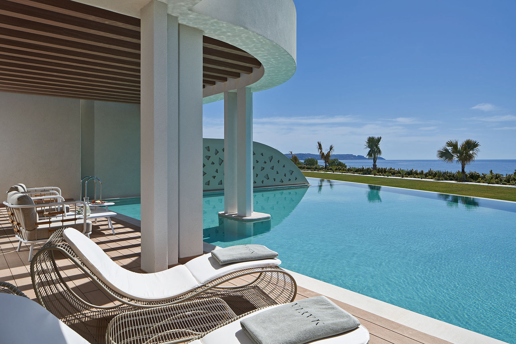 Loungers on the sunlit, poolside terrace of Mayia Exclusive Resort & Spa in Rhodes, Greece, an awarded, adults-only retreat recognised among the TUI Top 100 Hotels worldwide. 