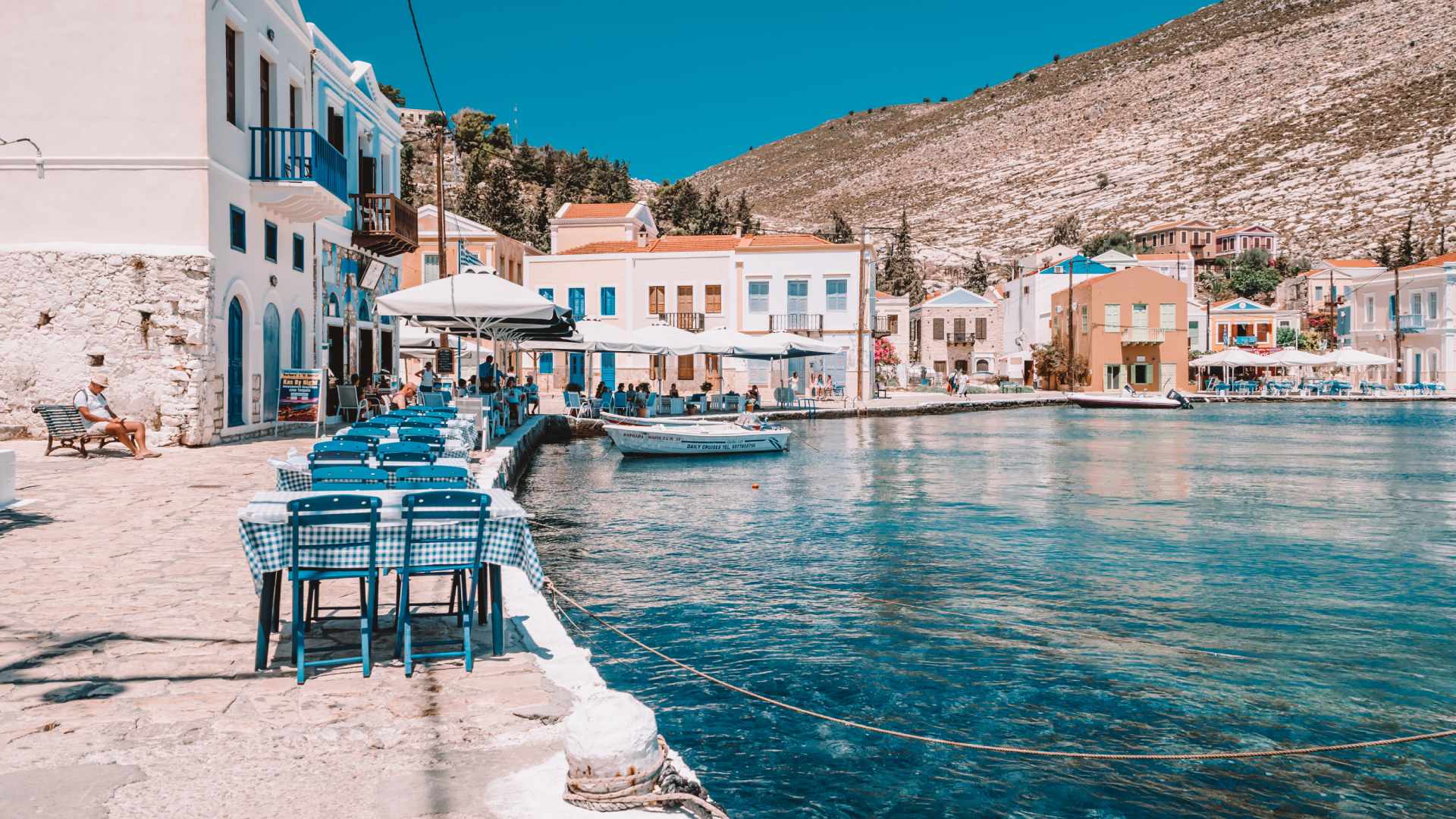 Tables and chairs lining the harbour of Kastellorizo, one of the best islands close to Rhodes, Greece to discover on a day trip. 