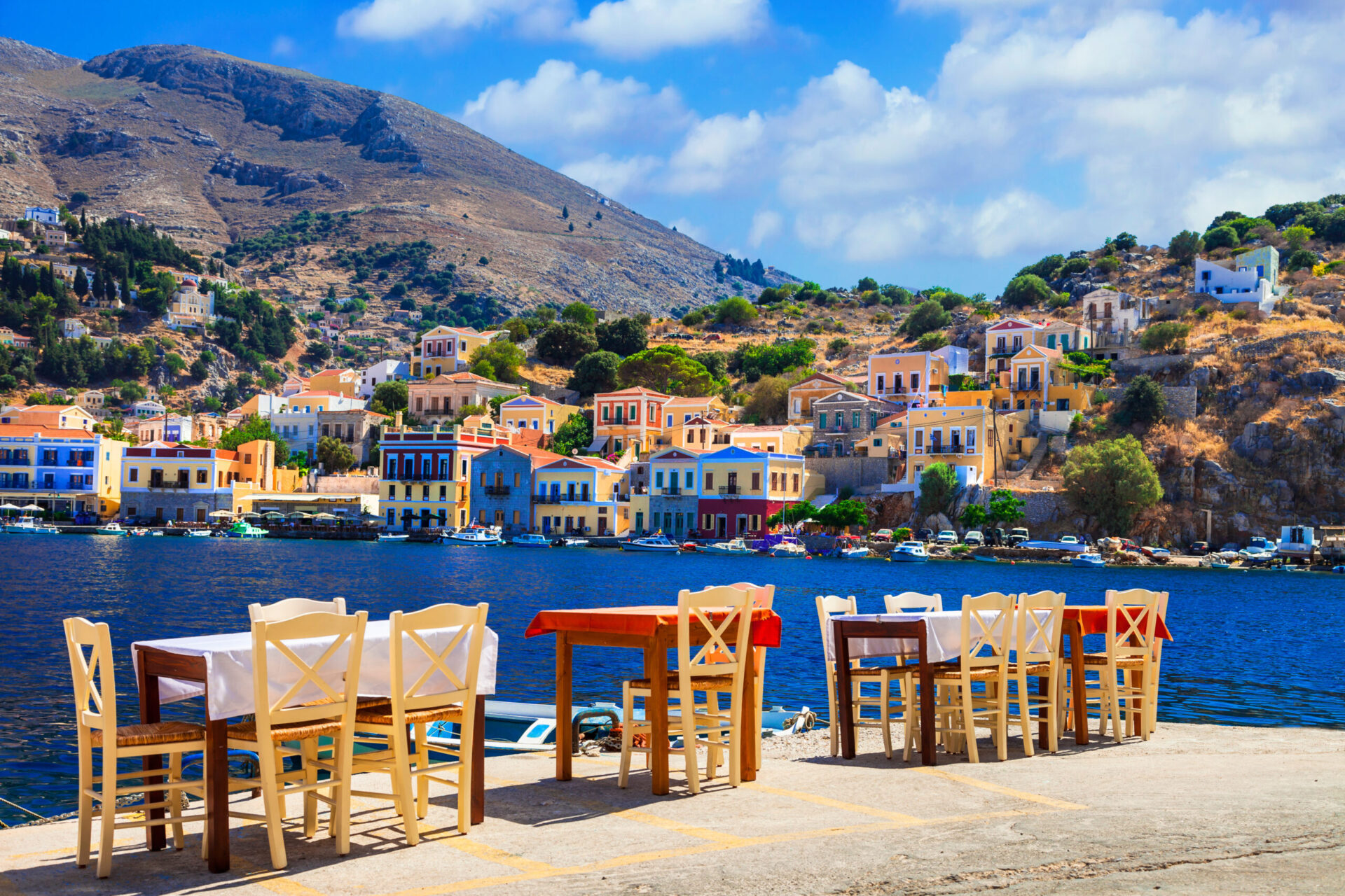 A pier with tables set on Symi island, one of the best islands close to Rhodes, Greece for day trips. 