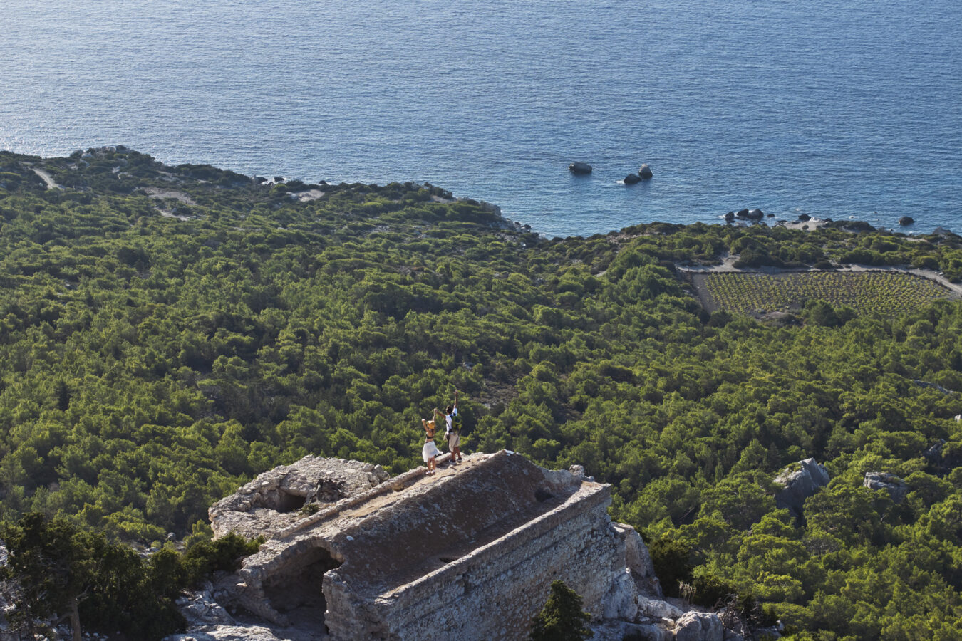 Couple atop of Monolithos Castle ruins in Rhodes, highlighting the connection between travel, nature, and place.