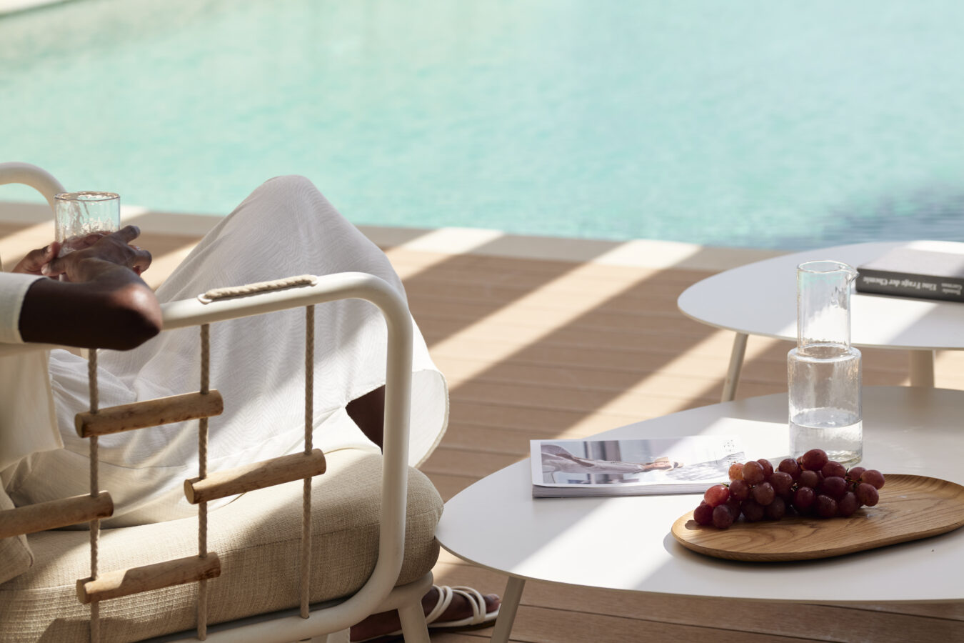 A guest relaxing on a sunbed, overlooking the pool of Maya Exclusive Resort & Spa, during a digital detox on holiday in Rhodes.