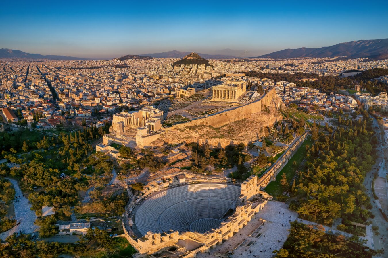 Panoramic view of central Athens bathed in bright winter sunshine, showing iconic classical landmarks under clear skies ideal for winter vacation ideas in Europe.